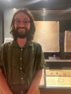 Garrett in front of a cuneiform tablet from Sargon II